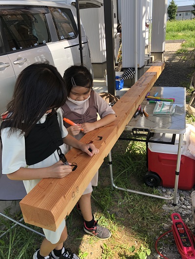 棟木に絵やメッセージを書くA様のお子さん